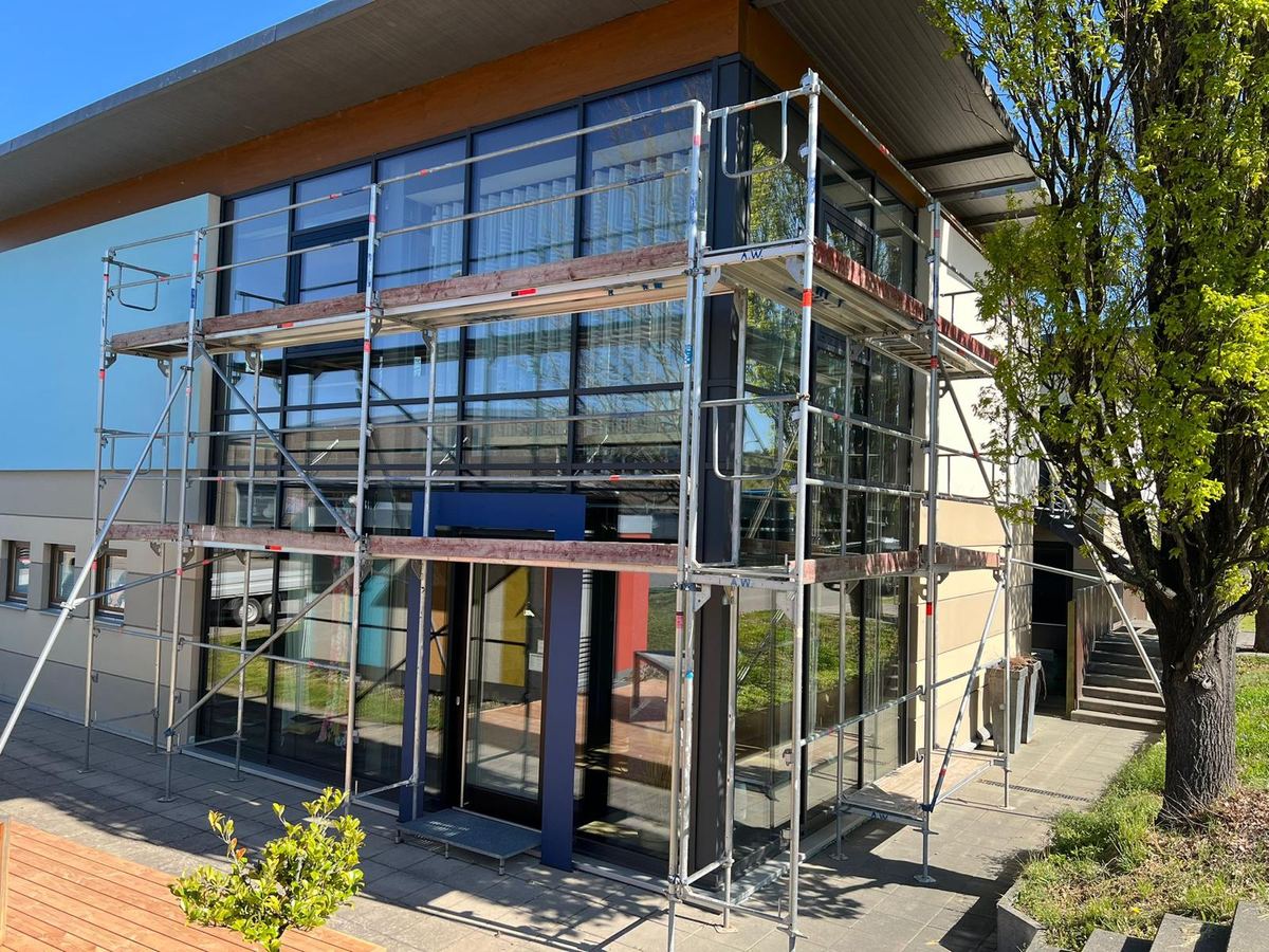 Monteur von Gerüstbau Weiß & Fricker auf einem fertig aufgebauten Gerüst